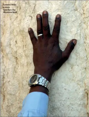 ??  ?? Connection: a man touches the Western Wall