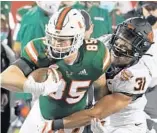  ?? RAOUX/AP ?? Oklahoma State safety Kolby Harvell-Peel stops Miami tight end Will Mallory after a reception during the Cheez-it Bowl .JOHN