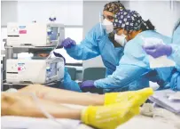  ?? MARIO TAMA / GETTY IMAGES ?? Clinicians work on intubating a COVID-19 patient at Louisiana's Lake Charles Memorial Hospital last month.