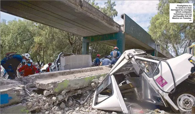  ?? AFP ?? Firefighte­rs try to remove a bus damaged by a bridge
which collapsed following a strong earthquake that hit Mexico on Tuesday.