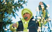  ?? ?? Tommy Golden, an electricia­n for the Bethlehem Public Works Department, places a string of lights on the tree Monday.