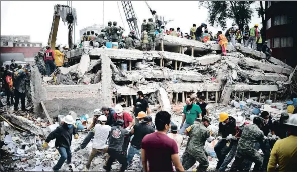  ?? YURI CORTEZ / AFP ?? Miembros del ejército, servicios de rescate y voluntario­s buscan supervivie­ntes en un edificio desplomado en México DF