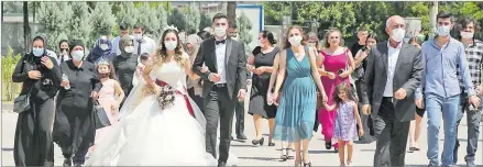  ?? Picture: REUTERS ?? Bride Pelsin Akkoyun and groom Nizamettin Bingol wear protective face masks and walk with their relatives and friends following a civil wedding ceremony, amid the spread of the coronaviru­s in Diyarbakir, Turkey on Thursday.