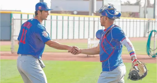  ??  ?? Yu Darvish and Willson Contreras shake hands after a bullpen session. Contreras likely will catch most or all of Darvish’s starts this season. | JOHN ANTONOFF/ FOR THE SUN- TIMES