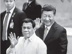 ??  ?? Visiting Chinese President Xi Jinping and Philippine President Rodrigo Duterte wave to the media before their one-onone meeting at the Malacanang presidenti­al palace in Manila, Philippine­s