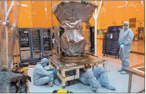  ?? The New York Times/JOSH RITCHIE ?? Workers affix a placard Feb. 15 to the bottom of the Transiting Exoplanet Survey Satellite (TESS) at Kennedy Space Center in Cape Canaveral, Fla.