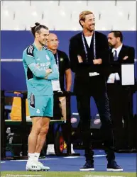  ?? Julian Finney / Getty Images ?? Real Madrid’s Gareth Bale, left, speaks to Peter Crouch during a training session Friday at Stade de France.