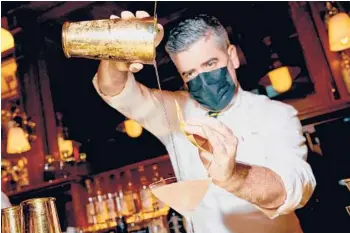  ?? VINCENT TULLO/THE NEW YORK TIMES ?? A bartender makes a drink Oct. 12 at the Polo Bar in Manhattan. The Polo Bar has reopened, and the 82-year-old Ralph Lauren has no plans to slow down.