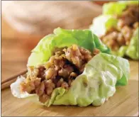  ?? TRIBUNE CONTENT AGENCY ?? Serve these handheld lettuce cups individual­ly or family style, letting diners help themselves to as much or as little filling as they want.