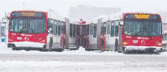  ?? ERROL MCGIHON ?? As of 8:40 a.m. Thursday morning, OC Transpo reported that 56 buses were ‘immobilize­d’, including this pair at Carlingwoo­d Mall.