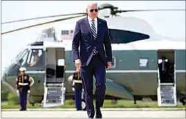  ?? ANDREW HARNIK / AP ?? President Joe Biden walks to board Air Force One at Quonset Point Air National Guard in North Kingstown, R.I. on Wednesday to travel back to Washington after attending the commenceme­nt for the United States Coast Guard Academy in New London, Conn.