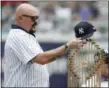  ?? JULIO CORTEZ — ASSOCIATED PRESS ?? Former Yankees pitcher David Wells puts his hat on the 1998 World Series trophy during a ceremony honoring the 1998 club prior to Saturday’s game at Yankee Stadium in New York.