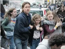  ?? Paramount Pictures ?? Brad Pitt, left, is Gerry Lane, Abigail Hargrove is daughter Rachel, and Mireille Enos is Karin, his long-suffering wife, in World War Z, yet another zombie offering.