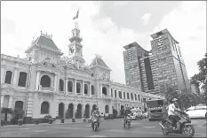  ??  ?? The City Hall, a French-colonial era building, with a nearby new shopping mall (right background) in downtown Ho Chi Minh City.