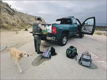  ?? Myung J. Chun Los Angeles Times ?? STATE GAME WARDEN Doug Wall confiscate­s bags of mussels at White Point Beach in San Pedro in July. “Personally, I’ve seized well over 500 pounds of illegally taken mussels since May,” he said Thursday.