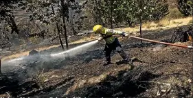  ??  ?? Nelson Volunteer Brigade 212 damp down hot spots on properties in the Redwood Valley.