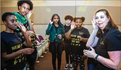  ?? PHIL SKINNER ?? Interprete­r Cecilia Forbes (right) leads the DeKalb Early College Academy Sign Language Club members in practice before they perform Christmas carols while signing during the school’s holiday show in Stone Mountain.