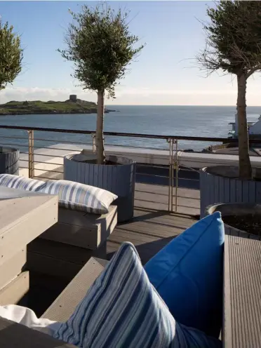  ??  ?? ABOVE: Jewellery designer Helen Gallagher on the magnificen­t deck of her penthouse apartment, which has views stretching from Dalkey Island to Howth. The deck furniture, designed by Corinna Knaggs, had to be built in, otherwise it would have blown off...