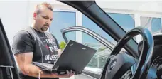  ??  ?? Wo liegt das Problem? Fachinform­atiker Paul Doliwa überprüft mit einem Laptop ein defektes Auto.