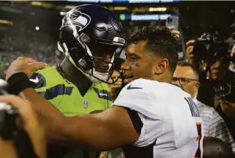  ?? Stephen Brashear / Associated Press ?? Seattle quarterbac­k Geno Smith (left) talks with Denver quarterbac­k and former teammate Russell Wilson after the Seahawks beat the Broncos and their old quarterbac­k 17-16 on Monday.