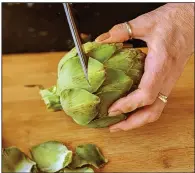  ??  ?? Snipping the thorny ends off of an artichoke’s leaves with kitchen shears will make it easier to handle.