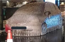  ??  ?? Iced up: A car stuck on a flooded street in East London