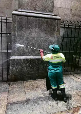  ??  ?? Agentes da prefeitura limpam pichações na Catedral da Sé, neste domingo (21)