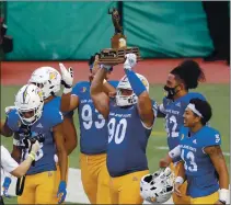  ?? MARCO GARCIA – THE ASSOCIATED PRESS ?? San Jose State players celebrate with the Dick Tomey Legacy Trophy after defeating Hawaii 35-24 on Saturday in Honolulu.