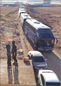  ??  ?? Members of Hayat Tahrir al-Sham group, led by Syria’s former Al Qaeda affiliate, watch as a convoy of busses gets ready to enter the towns of al-Foua and Kefraya to evacuate their residents yesterday. A deal was reached the day before for the...