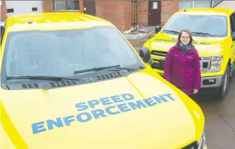  ?? SHAUGHN BUTTS ?? Jessica Lamarre, Edmonton’s acting director for traffic safety, reveals two of the photo radar trucks that got a bright makeover to make them more visible to motorists.