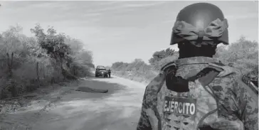  ?? FOTO: MARCO MILLÁN Elementos del Ejército y policías resguardan la escena del crimen. ??