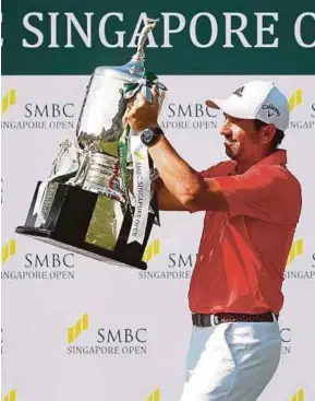  ??  ?? Sergio Garcia celebrates with the trophy after winning the Singapore Open yesterday.