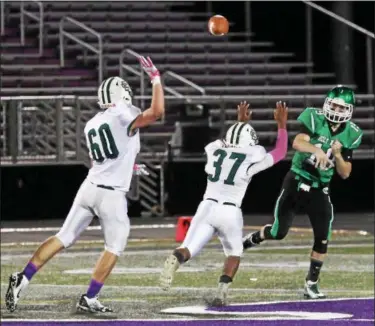  ?? RANDY MEYERS — THE MORNING JOURNAL ?? Holy Name quarterbac­k Joe Carter throws downfield and over the pass rush by Stephen Ferguson lll and Gabe Hirsch of Elyria Catholic.