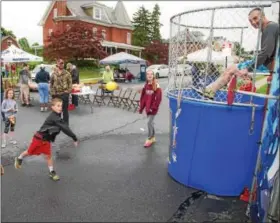  ?? SUBMITTED PHOTO - DENNIS KRUMANOCKE­R ?? Grant Wagaman attempts to put down Brandywine Heights Superinten­dent Andrew Potteiger in the dunk tank at the Topton Street Fair on May 20 as sister Harlowe and dad Michael look on.