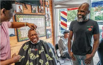  ?? Mark Mulligan / Staff photograph­er ?? Mayor Sylvester Turner laughs as he receives a haircut and talks to Gabriel Ismael, right, during a vaccine awareness event Saturday at Goode Looks Barber Shop on Scott Street.