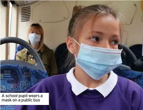  ??  ?? A school pupil wears a mask on a public bus