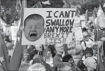  ?? KIRSTY WIGGLESWOR­TH/AP PHOTO ?? Anti-Brexit demonstrat­ors carry placards and EU flags in London on Saturday. In their first weekend session in 37 years, British lawmakers in Parliament debated whether to accept Prime Minister Boris Johnson’s proposed new divorce deal with the European Union.