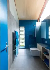  ??  ?? BATHROOM The couple’s bathroom is also decorated entirely in blue, to tie in with the kitchen. Tiles from Artedomus, including Vixel glass mosaics in turquoise, glitter and shine in the natural light that floods through the large skylight.