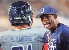  ?? HENRY TAYLOR/COMMERCIAL APPEAL ?? Jackson State coach Deion Sanders yells at safety Shilo Sanders on the sideline.