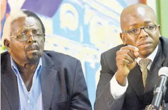  ?? FILE ?? Pearnel Charles Sr listens while his son, Pearnel Charles Jr, speaks to journalist­s during a press conference at the JLP’s headquarte­rs at Belmont Road, New Kingston, on February 3, 2014. Charles Sr will be quitting as member of parliament shortly.