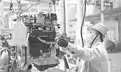  ?? XINHUA ?? NORMALITY returns in business in China as a worker operates at a workshop of the Dongan Auto Engine Co., Ltd. in Harbin City to work on units that will add to the 71,300 automotive engines sold by the company in the first two months of 2021.