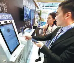  ?? PHOTOS BY ZHU XINGXIN / CHINA DAILY ?? From left: A staff member demonstrat­es facial recognitio­n payment technology at the Light of the Internet Expo in Wuzhen, Zhejiang province; visitors interact with a robot; visitors try out 5G technology.