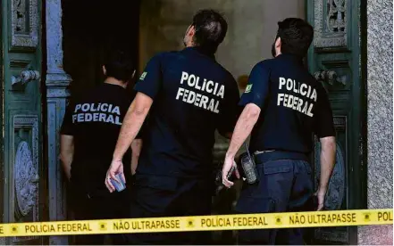  ?? Carl de Souza/AFP ?? Policiais federais inspeciona­m a entrada do museu para investigar as causas do incêndio