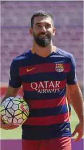  ??  ?? BARCELONA: Barcelona’s new player Turkish Arda Turan poses wearing his new jersey during his official presentati­on at the Camp Nou stadium, after signing his new contract with the Catalan club. — AFP