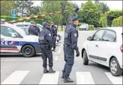  ??  ?? French police officers work at the crime scene in Magnanvill­e, west of Paris on Tuesday.