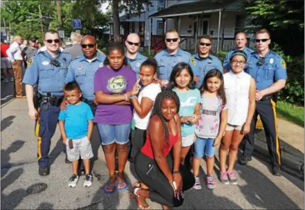  ?? FRAN MAYE – DIGITAL FIRST MEDIA ?? Police officers from Kennett Township and Kennett Square stand with children on Linden Street to celebrate National Night Out Tuesday night in Kennett Square.