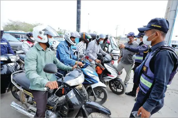  ?? HONG MENEA ?? Officers supervise a checkpoint on National Road 6 in Bak Kheng commune of Phnom Penh’s Chroy Changvar district on Wednesday.