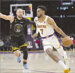  ?? Jae C. Hong Associated Press ?? TROY BROWN JR., shown driving against Stephen Curry, played 41 minutes and had 14 points in the Lakers’ 113-105 win over the Warriors. “I didn’t know I had played that many minutes,” he said.