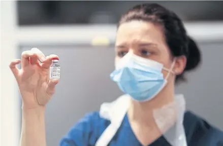  ?? AFP ?? A healthcare worker poses with a vial of the Oxford/AstraZenec­a coronaviru­s (Covid-19) vaccine at the Pentland Medical Practice, in Currie, Scotland yesterday.