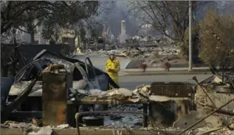  ?? JEFF CHIU, THE ASSOCIATED PRESS ?? Cal Fire forester Kim Sone inspects damage at homes destroyed by fires in Santa Rosa, Calif., on Thursday.